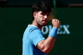 Carlos Alcaraz celebra un punto crucial en la final, con el puño en alto y determinación en su mirada.