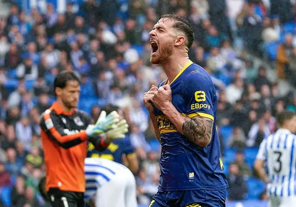 Jugador del Alavés celebra eufórico un gol contra la Real Sociedad. El portero observa con resignación.